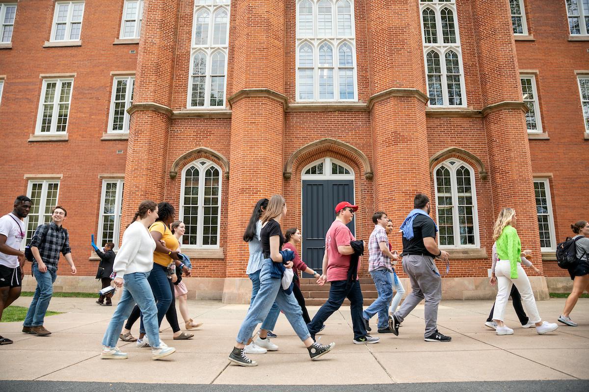 Students walk past Old Main as part of the Lux et Lex walk